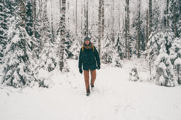 Full-length photo of tourist man in winter forest .