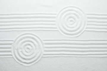 Fototapeta na wymiar White sand with pattern as background, top view. Zen, meditation, harmony