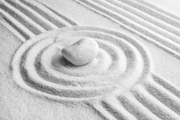 Fototapeta na wymiar White stone on sand with pattern. Zen, meditation, harmony