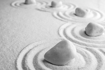Fototapeta na wymiar White stones on sand with pattern, space for text. Zen, meditation, harmony