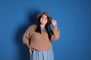 Beautiful overweight woman posing on blue background. Plus size model