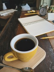 cup of coffee and notebook on table