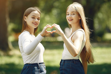 Beautiful girls in a jeans skirts. Women in a summer park.