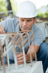 man builder at the top of the metal structure outdoors