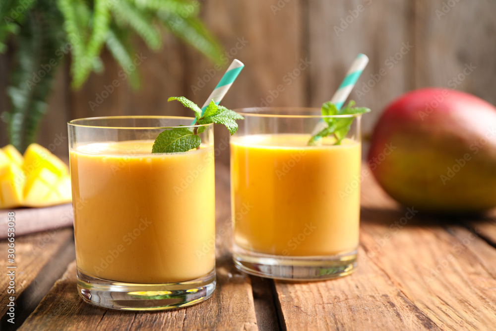 Wall mural fresh delicious mango drink on wooden table