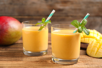Fresh delicious mango drink on wooden table