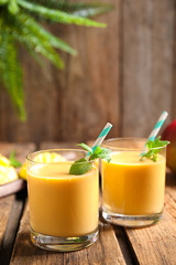 Fresh delicious mango drink on wooden table
