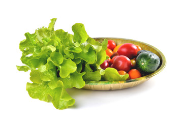 lettuce yellow and red tomatoes, cherry tomatoes and cucumber on a vintage dish white background, isolate, front view