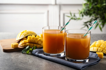 Fresh delicious mango drink on grey table
