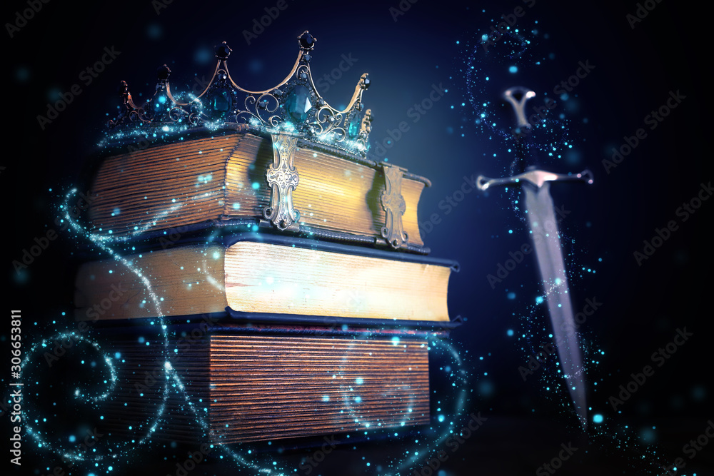 Wall mural low key image of beautiful queen/king crown over antique book and sword. fantasy medieval period. se - Wall murals