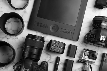 Flat lay composition with photographer's equipment and accessories on white marble table