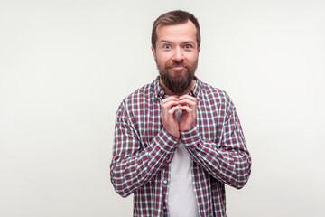 Portrait of sly scheming bearded man in casual plaid shirt looking at camera with smirk, having...