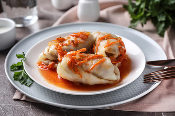 Delicious cabbage rolls served on grey marble table, closeup