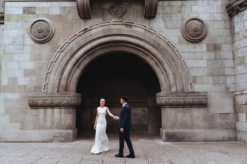 Happy bride and groom near old castle in wedding day