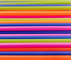 colored tubules for juice and cocktails on pink background. Colorful drink straws. straw, plastic free, reusable plastic drinking background, plastic free. Plastic pollution concept.