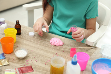 Obraz na płótnie Canvas Little girl making homemade slime toy at table, closeup