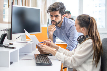 Business people discussing paper document together in office