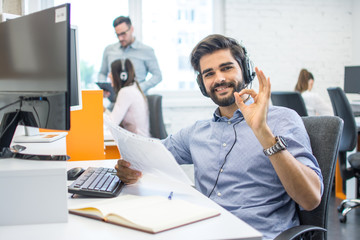 Telephone worker man showing ok sign with fingers at office