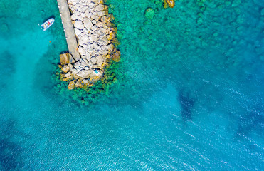 top view from drone on outstanding sea rocks, rocks and surf with waves. Beautiful blue water waves against rocky shore