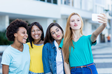 Multi ethnic young adult woman taking crazy selfie