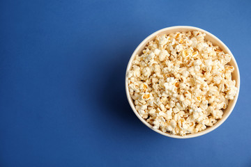 Tasty pop corn on blue background, top view. Space for text