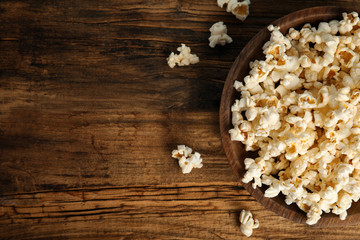 Tasty pop corn on wooden table, flat lay. Space for text
