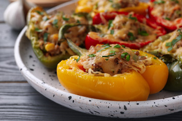 Tasty stuffed bell peppers on grey wooden table, closeup