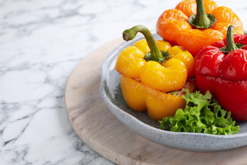 Tasty stuffed bell peppers on white marble table, closeup