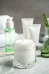 Obraz na płótnie Canvas Open jar of aloe cream on grey marble table. Organic cosmetics