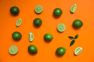 Flat lay composition with fresh juicy limes on orange background