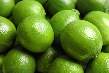 Fresh ripe green limes as background, closeup view