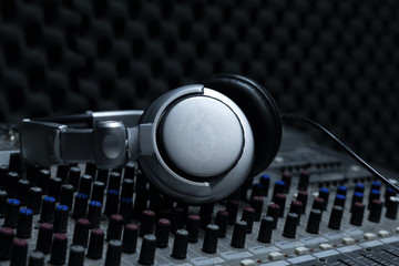 Obraz na płótnie Canvas Close-up of boutique recording studio control desk, dj headphones for professional disc, equipment for sound recording studio, mixer and DJ headphones
