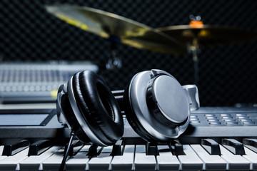 Piano keyboard with headphones for music, Headphones on piano keyboard, close up,headphones on electric piano background by the music instruments background.