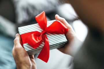 Man holding gift with red ribbon