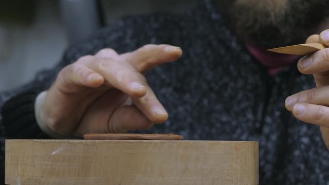 a craftsman cuts off an even circle of clay with a wooden knife to make a lid for a teapot from Yixing clay. Handmade clay teapot Yixing for tea ceremony. purple pottery teapot. 4k video. 59.94 fp