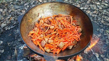 cooking Uzbek pilaf in a cauldron