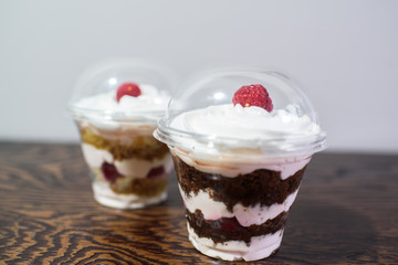 Delicious yogurt desserts with raspberries on a large wooden table
