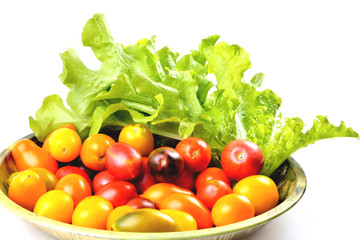 lettuce yellow and red tomatoes, cherry tomatoes on a vintage dish white background, isolate, front view