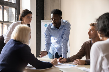 Focused diverse coworkers developing marketing strategy at office.