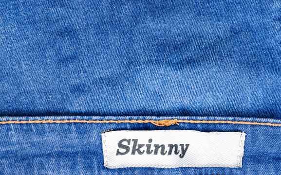 Close-up of blue jeans denim with tag skinny for lean people . Women and Men fashion accessory .Top view, copyspace.