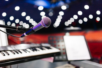 microphone with bokeh background at stage. (selective focus) behind the photo there is keyboard and...