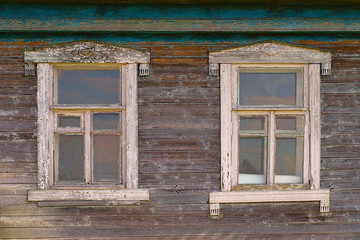 Fototapeta na wymiar Two windows of an old rustic wooden house close-up
