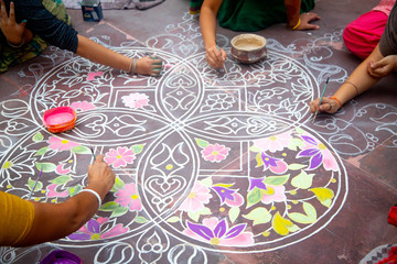Hands of girls making rangoli - indian mandala. Indian tourism. Indian traditional culture, art and religion. decorative element. abstract Oriental background, selective focus, lifestyle - obrazy, fototapety, plakaty