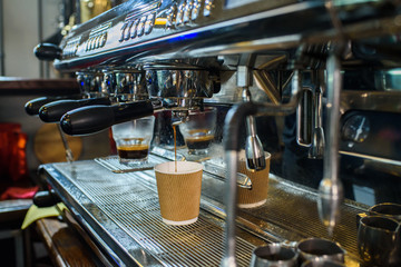 Barista makes fresh and tasty coffee on a coffee machine.