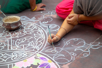 Hands of girls making rangoli - indian mandala. Indian tourism. Indian traditional culture, art and religion. decorative element. abstract Oriental background, selective focus, lifestyle