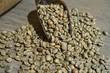 Fresh green coffee beans on a wooden table in a cozy coffee shop