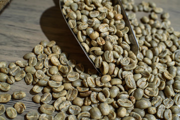 Fresh green coffee beans on a wooden table in a cozy coffee shop