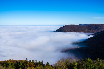 Germany, Magical aerial view above endless lake of clouds in valley of swabian jura nature landscape on sunny day with blue sky near stuttgart