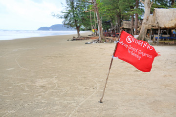 Red flag Warning Strong Current and Dangerous No Swimming in sea on Storm. Red flag flying on beach.