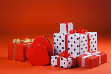 White and red gift boxes with red ribbon bow, isolated on red